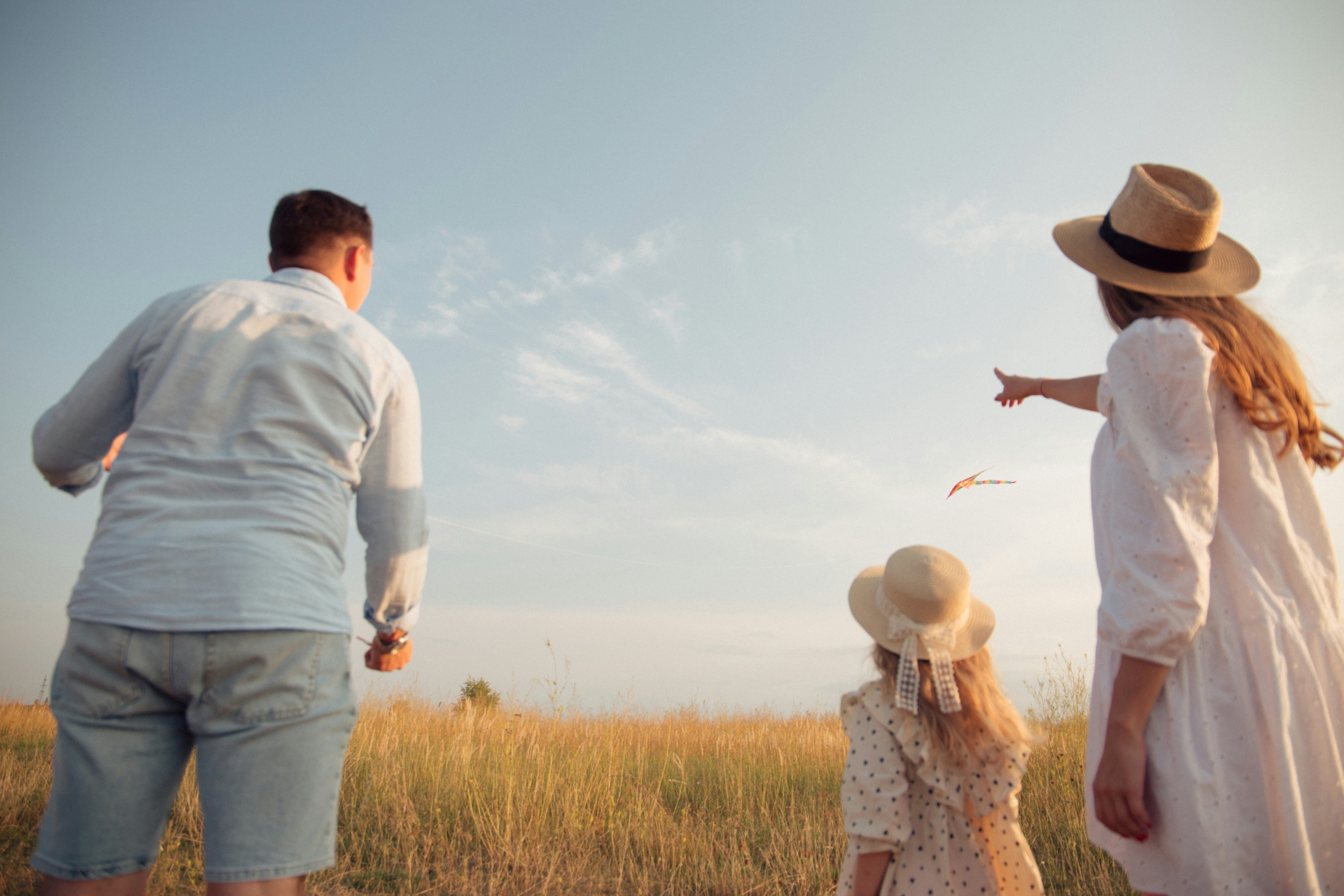 Family flying kite together in a field